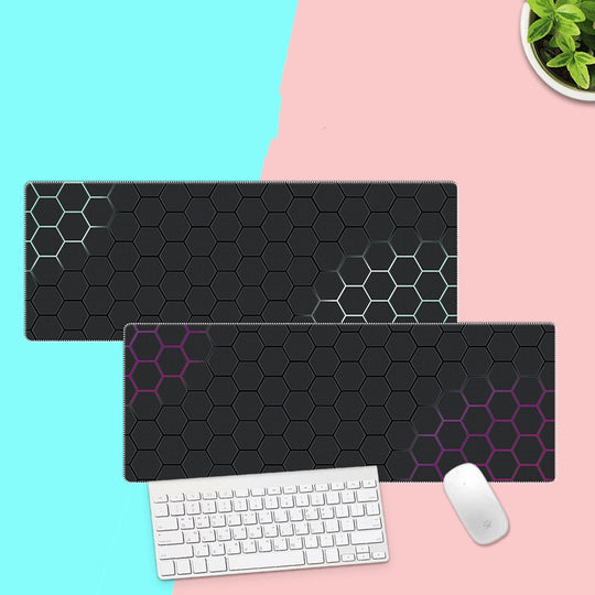 Two black hexagonal patterned mouse pads on a pink and blue background with a keyboard and mouse.